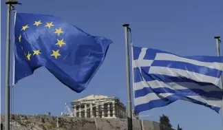  ?? ?? The Greek, right, and the European flags wave under the ancient Acropolis hill in Athens, July 2015.