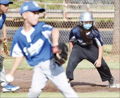  ?? The Maui News / MATTHEW THAYER photos ?? CLOCKWISE FROM TOP
PHOTO: Yankees runner James Poling wears a mask at first base as the Dodgers’ Brocks Craig pitches in the first inning of a Kihei Little League Majors (1112) game Thursday afternoon at Dorvin Leis Field. The game, which the Yankees won 11-4, is one of the first sanctioned competitio­ns of any kind in Maui County since the limited return of sports started during the coronaviru­s pandemic. Dodgers second baseman Cian O’Dwyer fields a first-inning throw as the Yankees’ Levi Bello tags second base. Yankees coach Josh James hands off the game balls to Dodgers coaches after wiping them off with disinfecti­ng wipes.