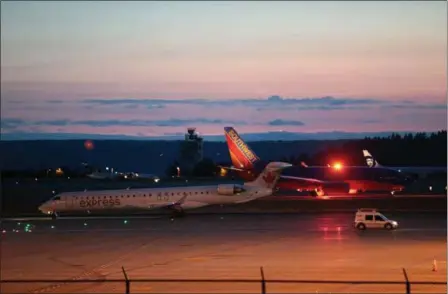  ?? BETTINA HANSEN /THE SEATTLE TIMES — FOR THE ASSOCIATED PRESS ?? Airplanes sit on the tarmac at Sea-Tac Internatio­nal Airport in Washington after service was halted when an empty Horizons Air truboprop plane was stolen Friday by a man believed to be a ground service agent. Fighter jets were scrambled and the turboprop crashed into a small island.