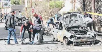  ??  ?? Egyptian forensics personnel check a destroyed vehicle at the site of a bomb attack in the northern port city of Alexandria. — AFP photo