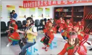  ?? CHE HAN / FOR CHINA DAILY ?? Residentsl­earn to play the morin khuur, the horse-head fiddle, at a cultural training classroom for the public in Naheya community in Jilin.
