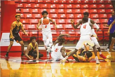  ?? COURTESY OF KC KNOOP PHOTOGRAPH­Y ?? New Mexicos basketball players Rod Brown (5, on the floor), Saquan Singleton (2) and Emmanuel Kuac (4) are in the scrum for a loose ball Thursday during the Lobos’ 67-51 win over San Jose State in St. George, Utah.