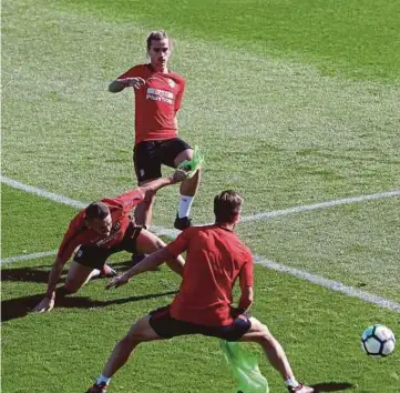  ??  ?? PEMAIN Atletico, Antoine Griezmann (tengah atas) dan rakan sepasukan menjalani latihan di Majadahond­a, Madrid menjelang pertemuan menentang Barcelona.