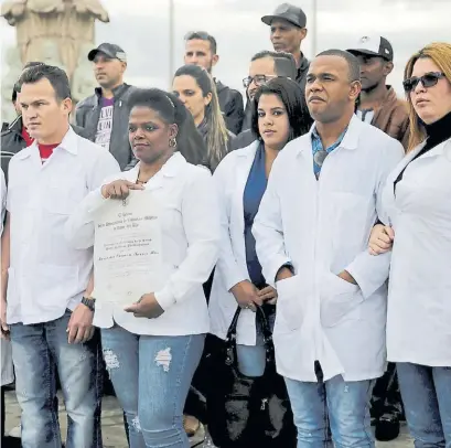  ??  ?? Huidos. Médicos cubanos protestan en Bogotá por su situación migratoria tras escapar de Venezuela. EFE