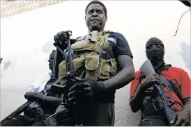  ?? ODELYN JOSEPH/THE ASSOCIATED PRESS ?? Barbecue, the leader of the G9 and Family gang, stands Tuesday with his fellow gang members after speaking to journalist­s in Port-au-Prince, Haiti.