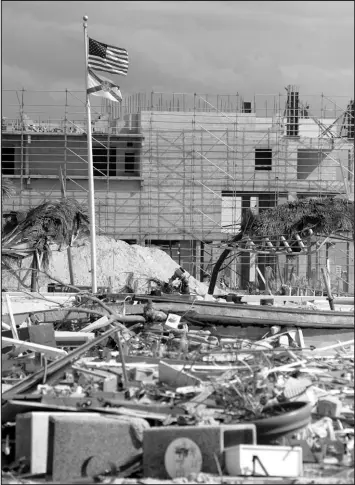  ?? JAY REEVES / ASSOCIATED PRESS ?? Flags fly over the rubble of Fort Myers Beach, Fla., on Oct. 9. Located on a coastal barrier island, the resort town was badly damaged by Hurricane Ian.