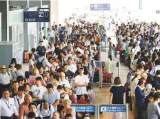  ?? AFP ?? Passengers stranded overnight at the Kansai Internatio­nal Airport due to typhoon Jebi queue for buses to transport them from the airport in Izumisano city yesterday.