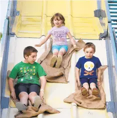  ??  ?? The Troxell family, Ricky, 9, from left, Ellie, 5, and Domonic, 6, of Nazareth, glide down the super slide Wednesday during the Bath Firefighte­rs Community
Days and Carnival. The fair runs through Saturday at Ciff Cowling Field in Bath. There are rides, games, food and live entertainm­ent. More informatio­n at www.bath community days.com