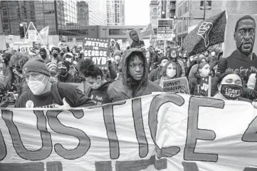  ?? VICTOR J BLUE/THE NEW YORK TIMES ?? Demonstrat­ors march Monday through Minneapoli­s as the jury began deliberati­ons in the murder trial of Derek Chauvin, a former police officer charged with the killing of George Floyd while in police custody.