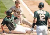  ?? Scott Strazzante / The Chronicle ?? The A’s Robbie Grossman is tagged out at home by Padres starter Garrett Richards.