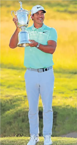  ??  ?? Brooks Koepka holds the winner’s trophy at the US Open at Erin Hills.