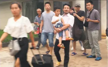  ?? Gerry Shih / Associated Press ?? Activists Hua Haifeng (carrying his son) and Li Zhao (third from left) were accused of stealing commercial secrets after investigat­ing labor conditions in a factory that produces brand shoes for Ivanka Trump.