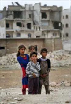  ?? LEFTERIS PITARAKIS - THE ASSOCIATED PRESS ?? In this May 29 photo, children stand in the outskirts of al-Bab, northern Syria. Nearly half of Syria’s pre-war population of 23 million have been uprooted from their homes— the overwhelmi­ng majority of them Sunni Muslims, who were among the first to...