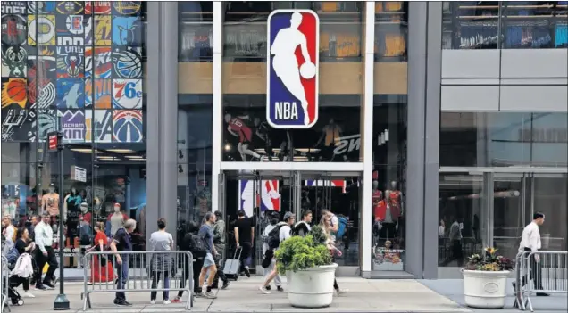  ??  ?? Gente paseando frente a la entrada de la tienda de la NBA situada en la Quinta Avenida de Nueva York.