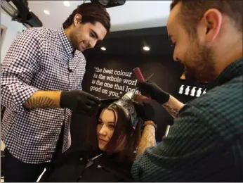  ??  ?? Raphael Azran, left, owner of the Colour Lab, applies a hair-colouring product on client Kat McCallum, centre, with co-worker Darren Kaine.