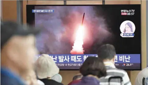  ?? — AFP ?? People watch a television news screen showing file footage of North Korea’s missile launch, at a railway station in Seoul.