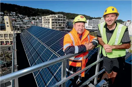  ?? PHOTO: FAIRFAX NZ ?? Ben Cloake, left, sales manager at Sunshine Solar and Chris Sperring, central area manager for YHA New Zealand, atop the Wellington YHA hostel, where solar panels are going in as part of a $2.7m project understood to be the largest solar panel...