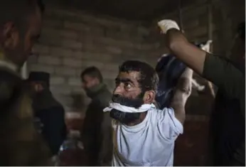  ?? ALI ARKADY/VII PHOTO ?? Mahdi Mahmoud is suspended by his wrists from the ceiling inside an Iraqi Emergency Response Division branch.