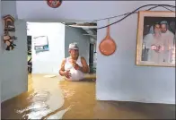  ?? LUIS ROBAYO / AGENCE FRANCE-PRESSE ?? A man wades through floodwater in his house in Cali, Colombia, on Tuesday after a downpour caused the overflowin­g of the Cauca river. The South American country remains on alert due to heavy rain which, since March, has left 389 people dead.