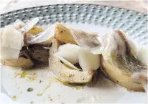  ??  ?? Artichokes are braised in broth and topped with whisper-thin strips of lardo.