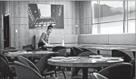  ?? ANTONIO PEREZ/CHICAGO TRIBUNE ?? A worker cleans a restaurant table in Chinatown Friday. Fewer people are dining out.