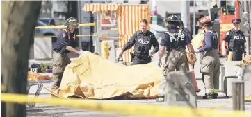  ?? — Reuters photo ?? Firemen cover the body of a victim in the ramming incident.