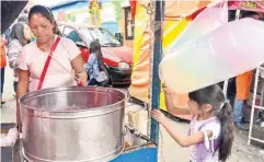  ??  ?? Vendedora de algodones de azúcar en una de las ferias patronales de la delegación Cuajimalpa en la Ciudad de México. La imagen es actual, 2017.