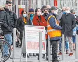  ?? Martin Meissner The Associated Press ?? People wait Thursday at a coronaviru­s test center in Cologne, Germany. The city exceeded the warning level of 50 new infections per 100,000 inhabitant­s in seven days.