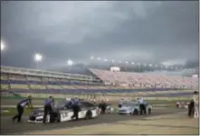  ?? KAREEM ELGAZZAR — THE CINCINNATI ENQUIRER VIA AP ?? Car are moved off pit row as storms move in on the Kentucky Speedway in Sparta, Ky. Friday at