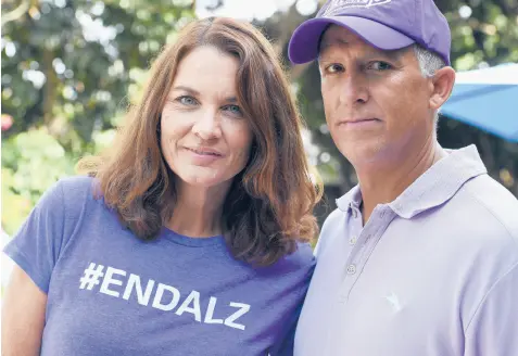  ?? STEVE NESIUS/AP ?? Michele Hall, who was diagnosed with early Alzheimer’s, with husband Doug in their Florida backyard in June.