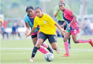  ?? FILE ?? Cavalier’s Liha Williams (centre) gets away from Frazsiers Whip’s Nevillegai­l Able during the final of the Jamaica Women’s Knockout football competitio­n at the UWI-JFF Captain Horace Burrell Centre of Excellence on May 13, 2023.