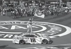  ?? Rachel Luna/Associated Press ?? ■ Kyle Busch stands on his car Sunday after winning the NASCAR Cup Series auto race at Auto Club Speedway in Fontana, Calif. The win was the 200th for Busch across NASCAR’s three national series.