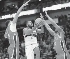  ?? GERALD HERBERT/ASSOCIATED PRESS ?? Wizards guard John Wall drives between Pelicans forward Anthony Davis (23) and forward Darius Miller (21) during Washington’s loss Wednesday night.