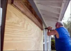  ?? JOSHUA BOUCHER/NEWS HERALD VIA AP ?? David Hayes boards up a window at this home in Panama City, Fla., as Hurricane Michael approaches on Tuesday.