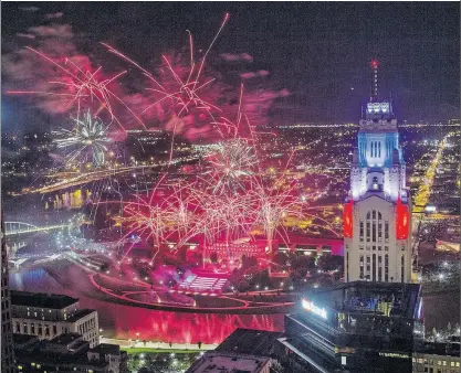  ?? [ADAM CAIRNS/DISPATCH] ?? The colorful fireworks display and the lights of the LeVeque Tower made for a spectacula­r scene Monday night over Downtown. This photo was taken from the Rhodes Tower.