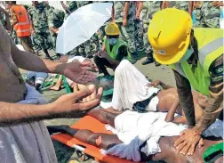  ?? PICTURE: AP ?? LUCKY: A pilgrim is treated by a medic, while another looks on and prays.