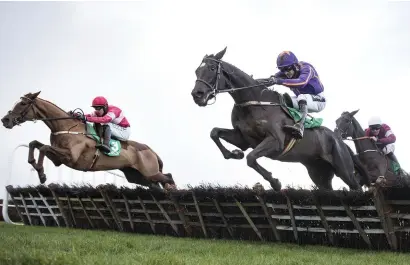  ??  ?? Easy Game, with Ruby Walsh up (right), jumps the last alongside stablemate Getareason on the way to winning the Navan Novice Hurdle