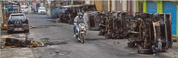  ?? (Foto AFP) ?? Beberapa kenderaan polis hangus terbakar di kawasan Devara Jevana Halli selepas penunjuk perasaan berang susulan catatan dalam Facebook yang menghina Rasulullah dibuat anak saudara seorang ahli politik India.