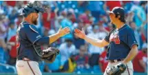  ?? AP PHOTO/PATRICK SEMANSKY ?? Atlanta Braves catcher Brian McCann, left, and relief pitcher Luke Jackson celebrate closing out Sunday’s win over the Nationals.