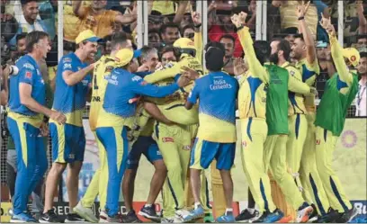  ?? ?? Chennai Super Kings’ captain MS Dhoni lifts Ravindra Jadeja as players celebrate their win at the end of the Indian Premier League (IPL) final against Gujarat Titans at the Narendra Modi Stadium in Ahmedabad on Monday. (AFP)