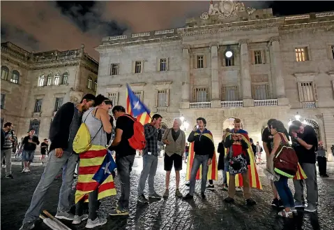  ?? PHOTO: REUTERS ?? People wrapped in Estaladas (Catalan separatist flags) listen to a statement by Catalan President Carles Puigdemont at Sant Jaume Square in Barcelona.