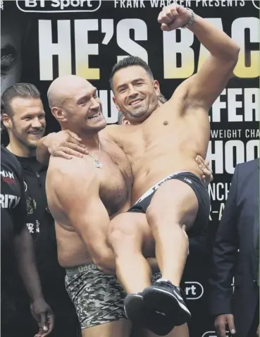  ??  ?? Tyson Fury lifts Albanian opponent Sefer Seferi off his feet at the weigh-in in Manchester.