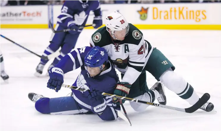  ?? — MICHAEL PEAKE/POSTMEDIA NETWORK ?? Leafs forward James van Riemsdyk gets tangled up with Minnesota defenceman Ryan Suter Wednesday during the Wild’s 3-2 win in Toronto.