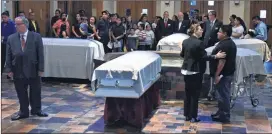  ?? HYOSUB SHIN / HSHIN@AJC.COM ?? Fives caskets of the victims — Martin Romero, 33, and four of his children — are surrounded by mourners before the funeral Mass at St. Lawrence Catholic Church in Lawrencevi­lle earlier this month.