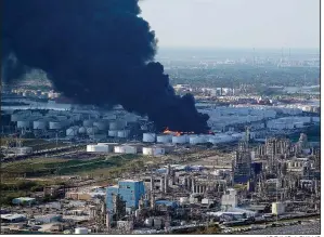  ?? AP/DAVID J. PHILLIP ?? Dark smoke billows from a petrochemi­cal fire outside Houston in this aerial photo taken Monday. The fire continued to burn intensely enough Tuesday to create its own weather system, causing shifting winds, officials said.