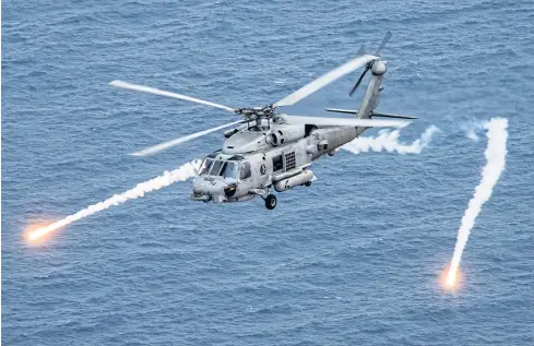  ?? REUTERS ?? A US Navy MH-60R Sea Hawk helicopter fires chaff flares during a training exercise in the Philippine Sea in April, 2017.