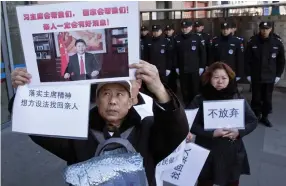  ??  ?? Relatives of passengers onboard the missing Malaysia Airlines Flight 370 demand that the Chinese government continue the search, with banners showing Chinese President Xi Jinping and the words "Don't Give Up" near the Foreign Ministry in Beijing. (AP)