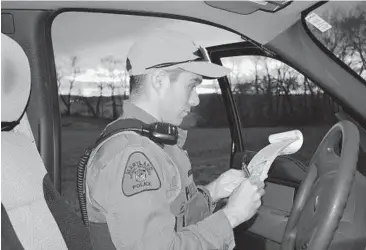  ?? MARYLAND DEPARTMENT OF NATURAL RESOURCES ?? Maryland Natural Resources Police Officer 1st Class Chris Warden writes a citation. In addition to enforcemen­t, the DNR focuses on safety education, requiring hunters born after 1977 to attend classes or take part in online training.