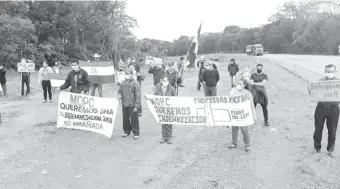  ??  ?? Pobladores se manifestar­on ayer en ruta PY02 para exigir que el MOPC les pague por sus tierras.