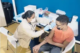  ?? JAMES ESTRIN/THE NEW YORK TIMES ?? A student receives a second dose of the Pfizer vaccine Tuesday at the Morris Heights Health Center in the Bronx borough of New York City.